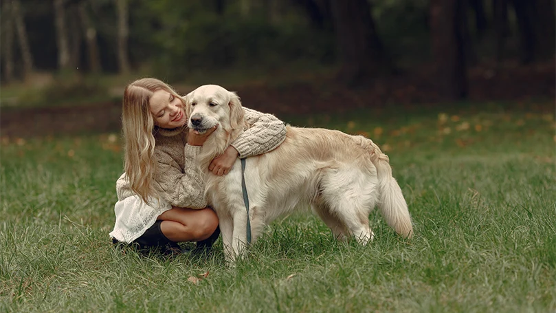 et billede af en kvinde, der krammer en hund