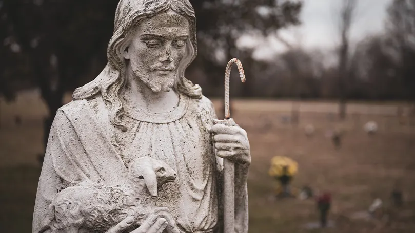 Et billede af en præstestatue og en religiøs figur