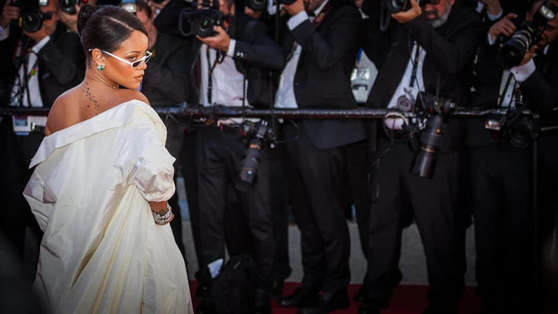 et billede af rihanna, der poserer foran journalister