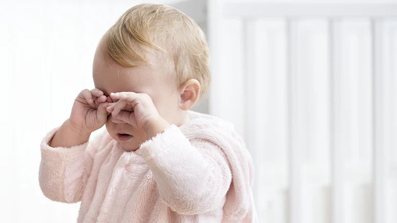 Et billede af en baby, der gnider sig i øjnene