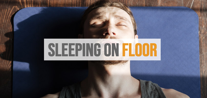 Billedet viser en person, der sover på gulvet.