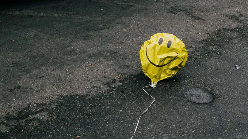 Et billede af en lufttom ballon med en smiley på.