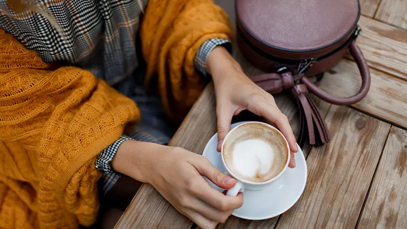 Et billede af en person, der drikker kaffe udenfor