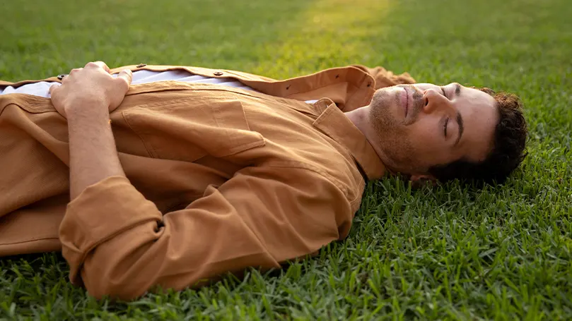 en mand, der sover på græs