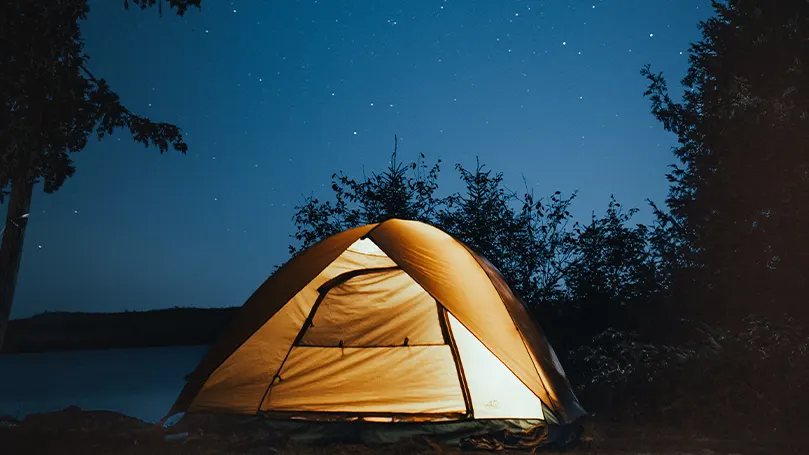 Et billede af et telt med et lys indeni