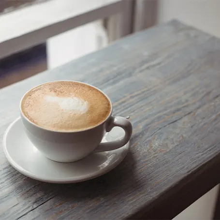 Et billede af en kop kaffe på et bord.